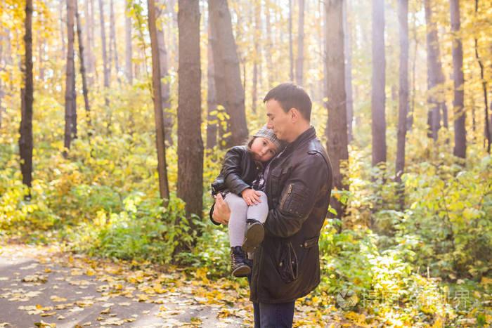 父亲, 家庭和休闲概念-在秋季公园里抱着小女儿的爸爸