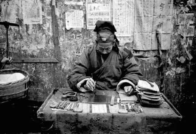 1941年,重庆,街边一位穿有布丁衣服的算命先生.